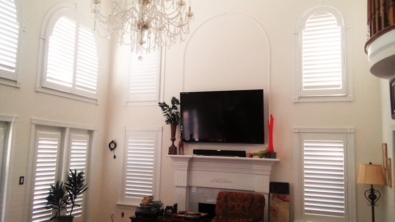 St. George great room with wall-mounted television and high-ceiling windows.